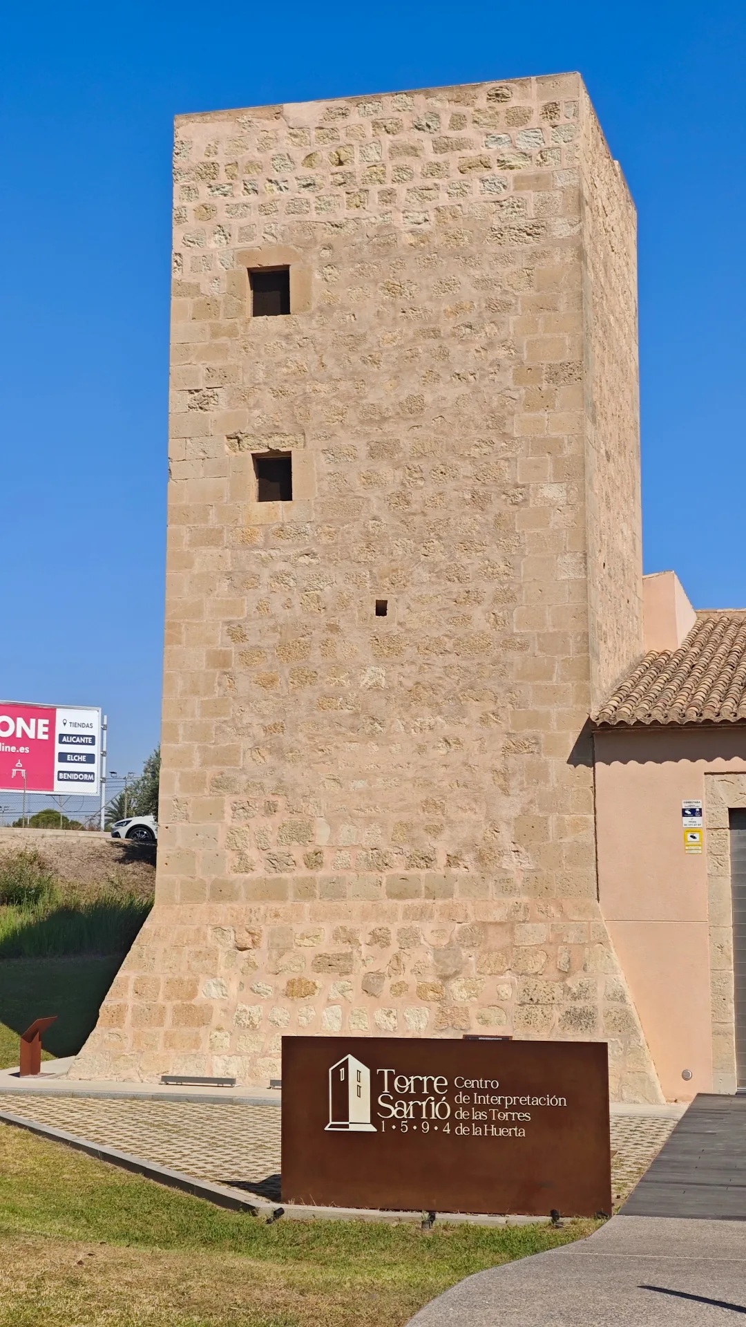 Façana frontal de la Torre Sarrió: base en talús, carreu als angles i aspitlleres